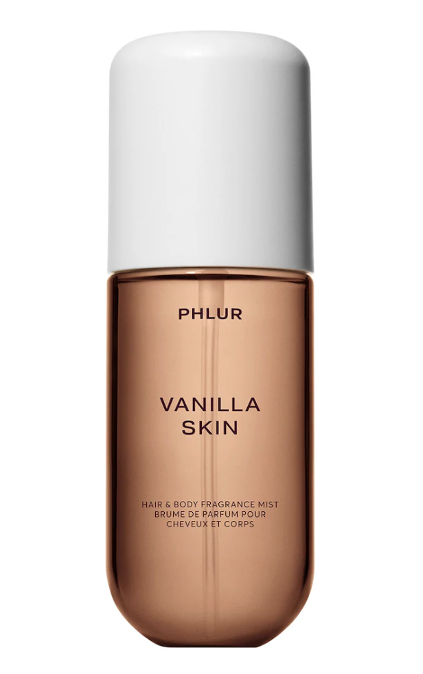 A bottle of Phlur Vanilla Skin Body and Hair Fragrance Mist with a frosted amber bottle and a white cap.