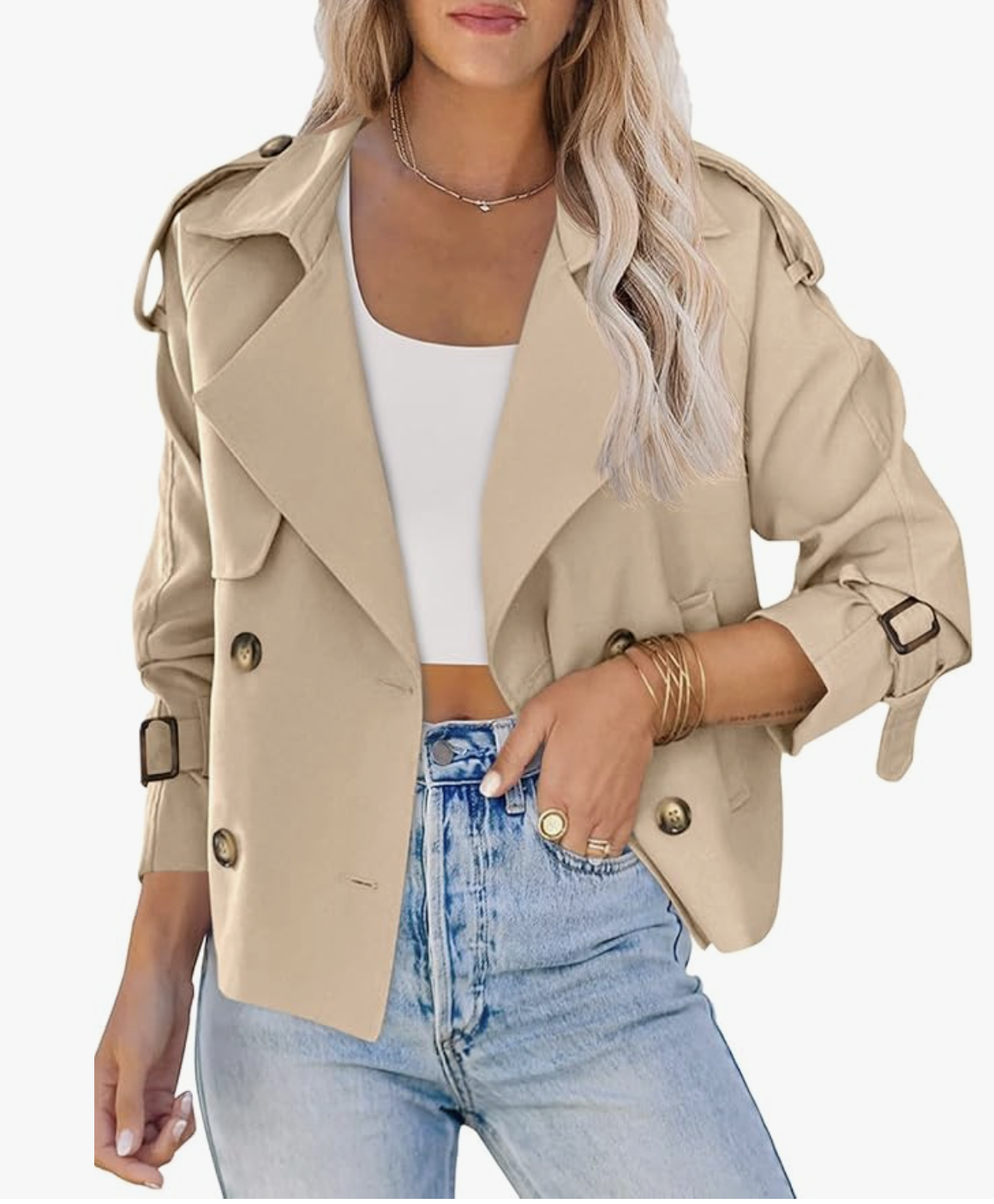 A woman wearing a beige cropped double-breasted trench coat with light wash jeans, a chic spring 2026 wardrobe essential for layering.