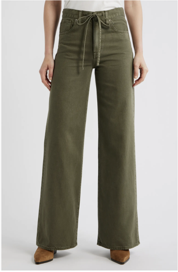A close-up shot of a model wearing the Madewell Ultimate Wide-Leg Jeans in a muted olive green shade called Faded Ivy, featuring a drawstring tie-waist.