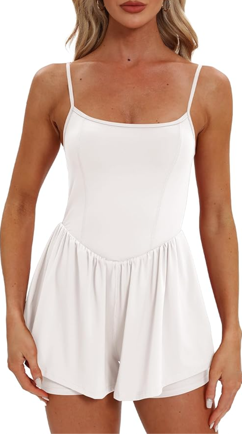 A woman wearing a white, double-lined sleeveless romper with spaghetti straps and a flowy short silhouette.