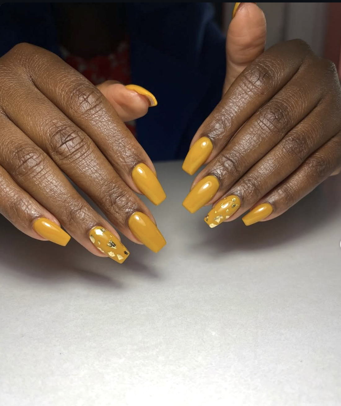 Short nails painted a muted ochre mustard yellow.