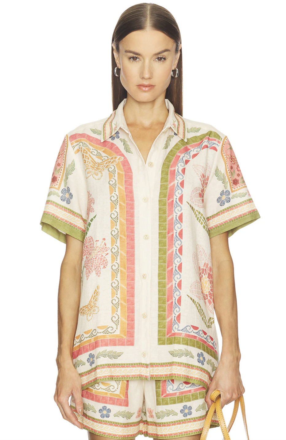 A woman wearing a lightweight, tropical-print button-down linen shirt and matching shorts, styled for a resort-casual Hawaii vacation look.