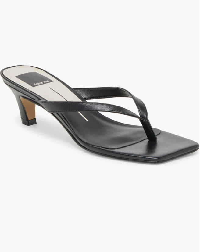 A close-up of a black leather kitten heel mule with a sharp pointed toe and thin delicate straps.