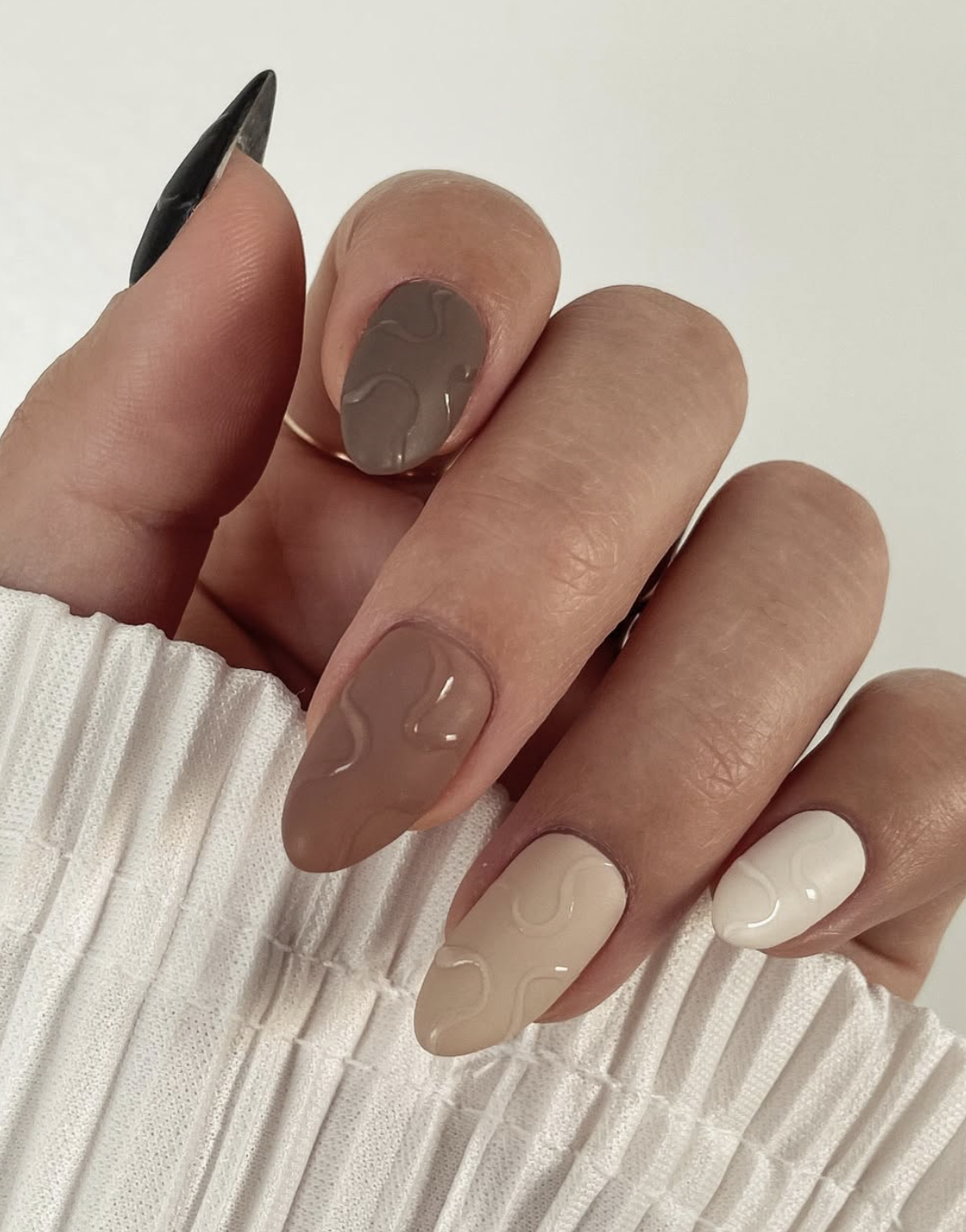 matte caramel with a glossy tip manicure photographed close up on hands.