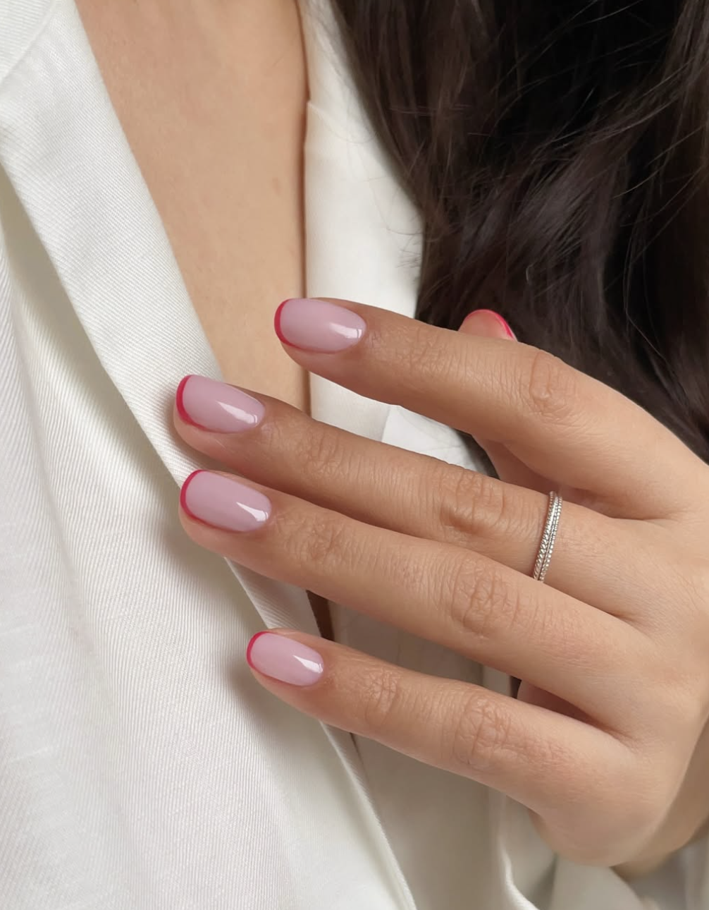 Long almond-shaped nails with a translucent pink base and a bold, classic red French tip.