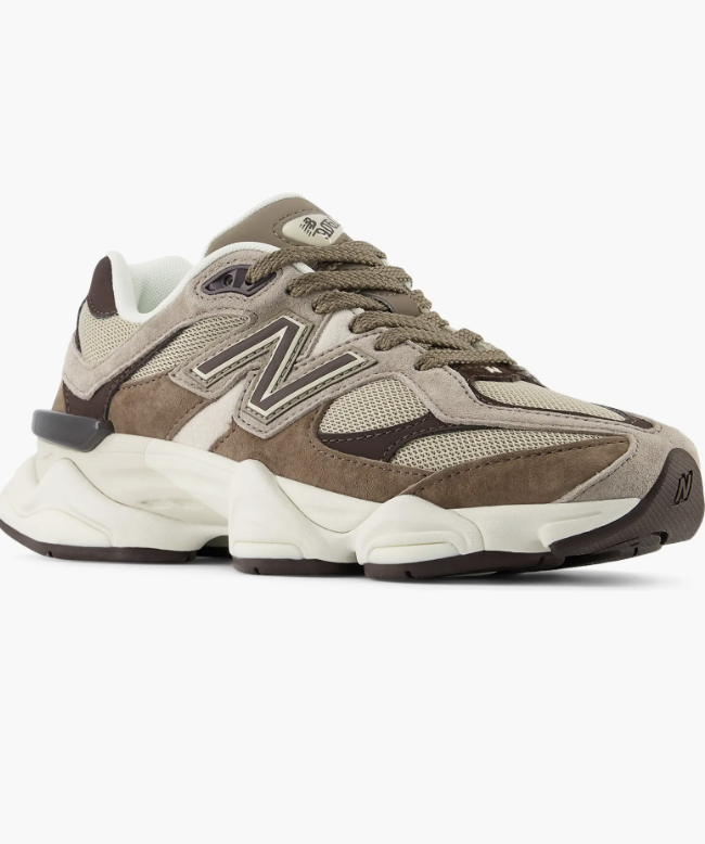A pair of New Balance 9060 sneakers in a mushroom and brown colorway with a chunky sculpted sole and mesh panels.
