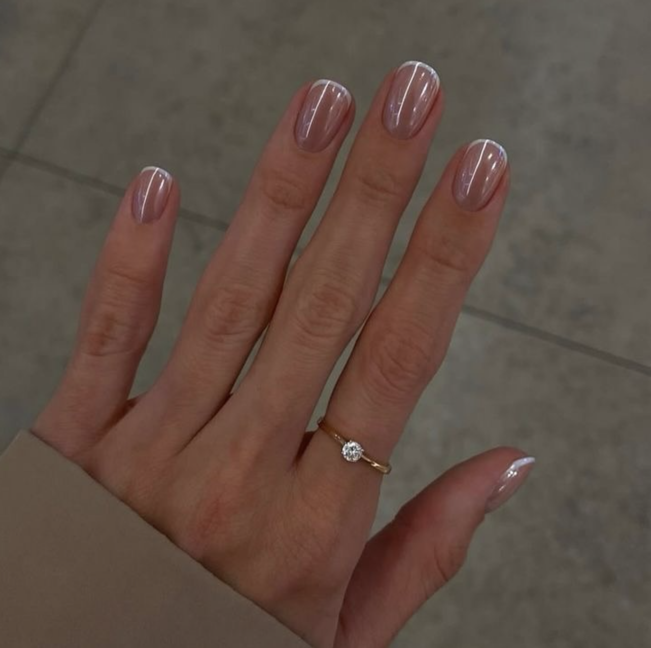 Short, round nails showcasing a clean, classic glazed donut finish with a soft pearl-white chrome shimmer.