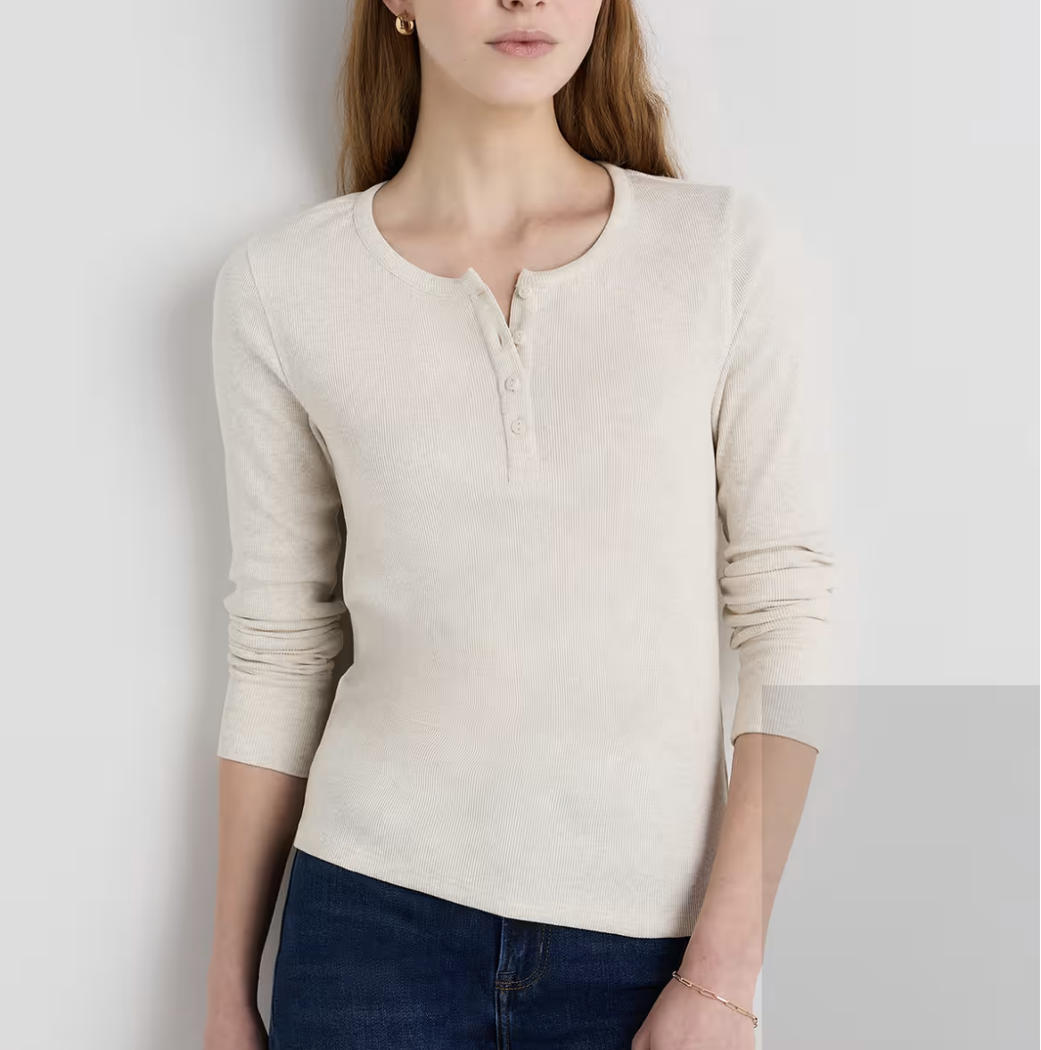Cream fitted long-sleeve henley top with button details.