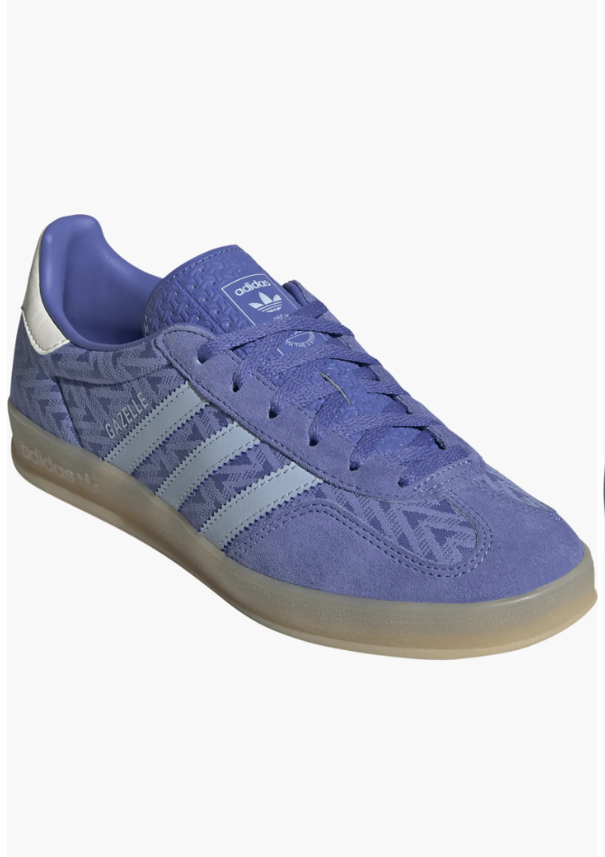 A close-up of a light blue and purple patterned suede Adidas Gazelle Indoor sneaker featuring light blue leather stripes and a translucent gum sole.