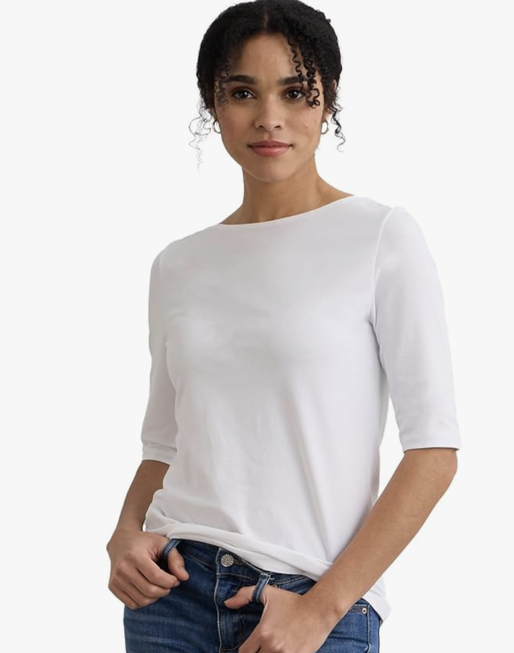A woman wearing a white half-sleeve boat neck top made of organic Pima cotton, a core spring wardrobe essential for 2026.