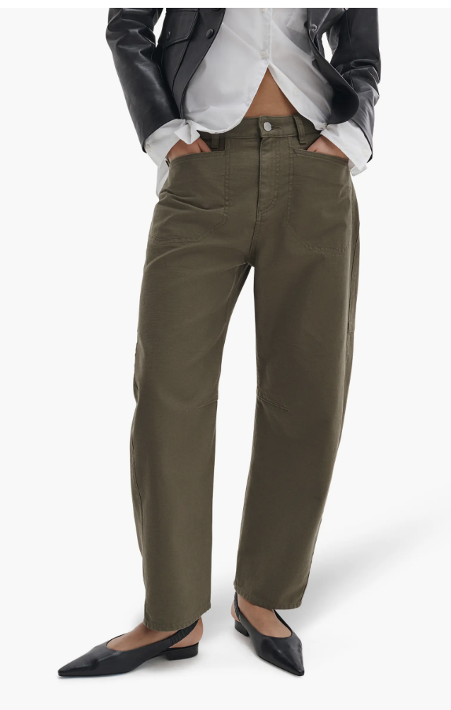 A person wearing olive green low-waisted cargo pants with a drawstring waist, styled with a white button-down shirt and a black leather jacket.