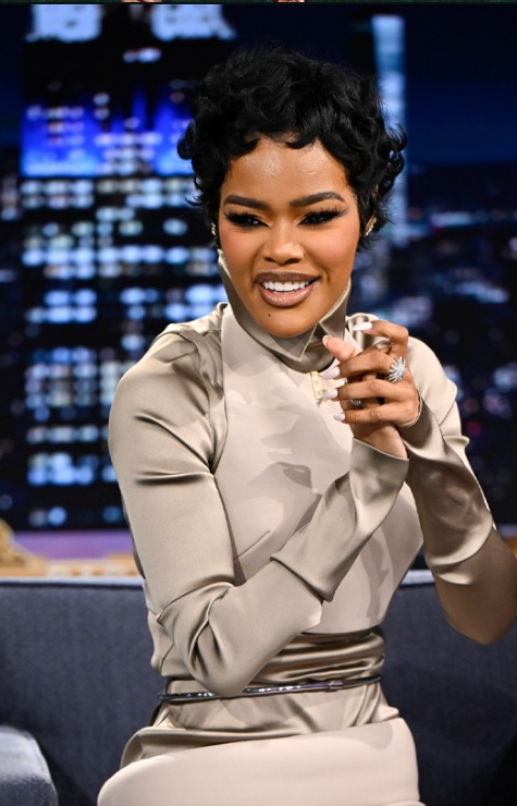 Teyana Taylor wearing a muted, warm-neutral taupe silk dress, illustrating how soft, earthy tones and a blended chroma harmonize with the Soft Autumn season.