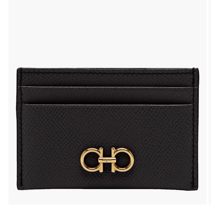 A close-up shot of a luxury black leather Ferragamo Gancini card case, featuring the iconic gold Gancini logo hardware on the front.