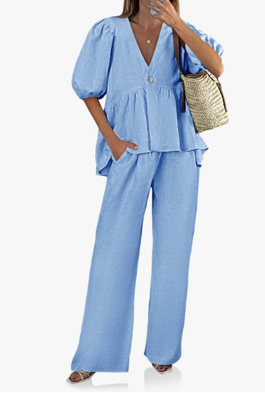A chic two-piece summer outfit featuring a relaxed, short-sleeve light blue linen button-down top with puff sleeves paired with matching high-waisted, wide-leg linen pants.