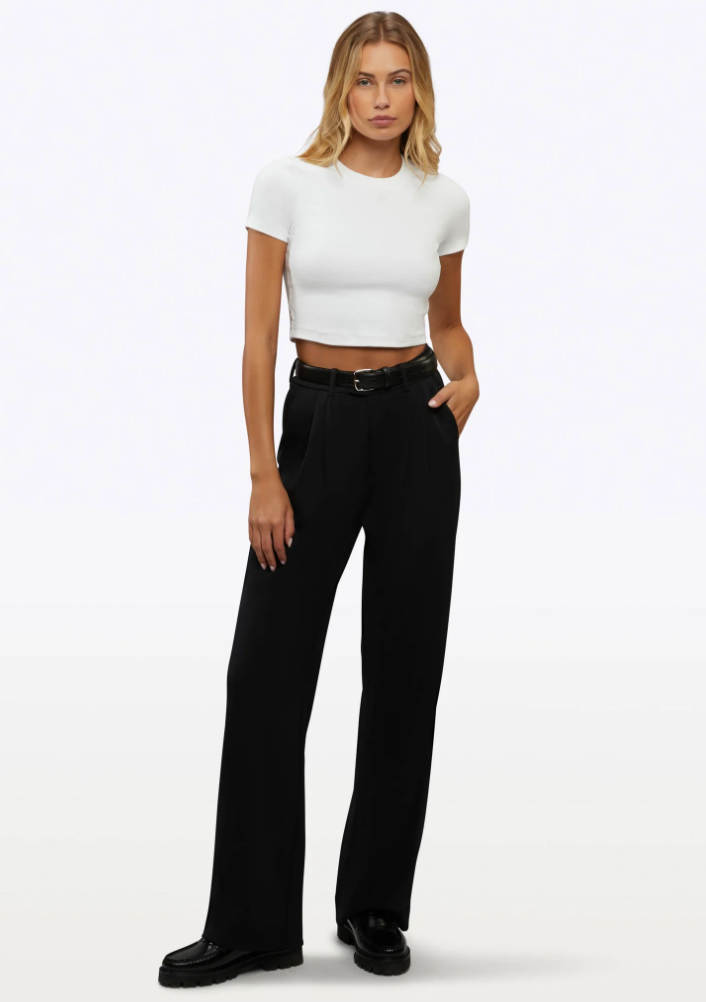 Woman wearing the Cuts Tomboy Tee, a cropped white t-shirt with a curved hem that isn't see-through.