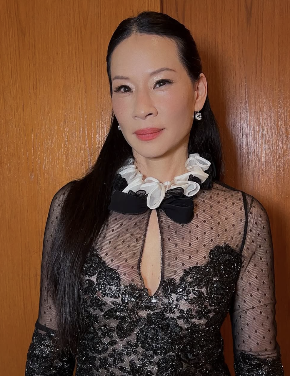Lucy Liu wearing a black lace dress with a ruffled white collar, demonstrating how cool-porcelain skin tones and soft coloring align with the Light Summer season.