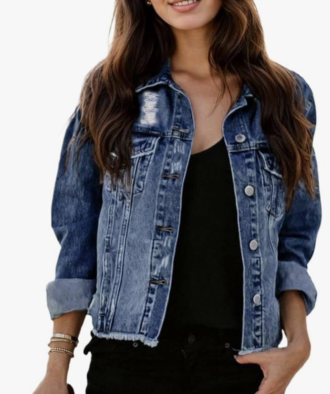 A woman wearing a medium-wash Distressed Frayed Ripped Jean Jacket with a raw hem and button-front closure, styled over a black tank top for a summer BBQ outfit.