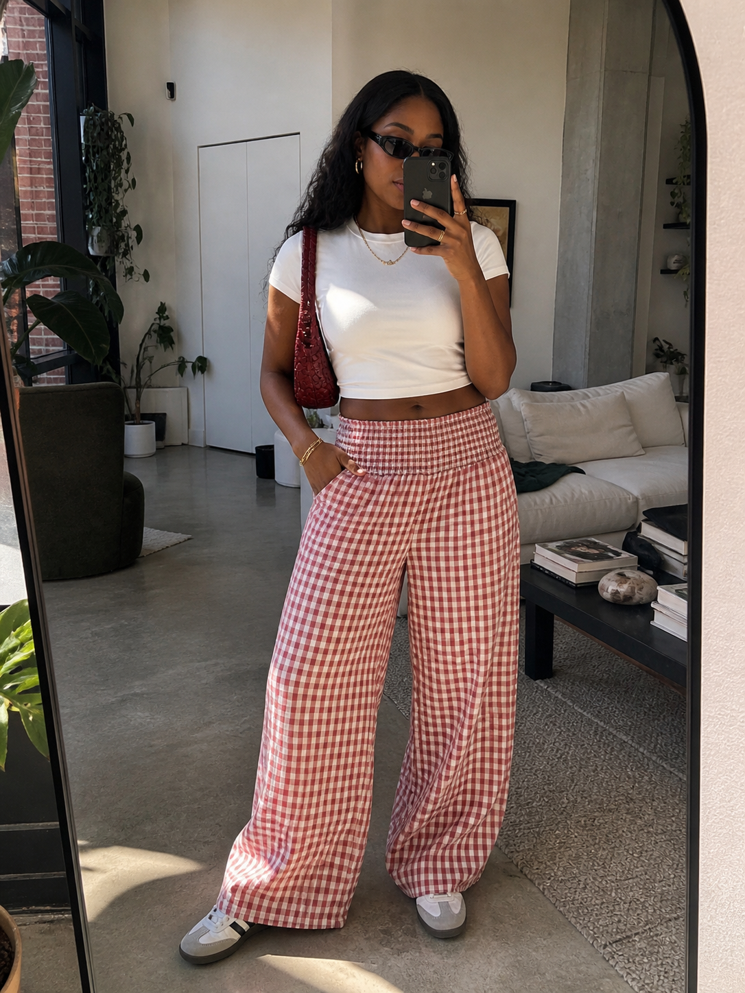 Fashion editor wearing high-waisted red and white gingham wide-leg pants paired with a white t-shirt and dark sunglasses, demonstrating a 2026 pattern-mixing outfit formula.
