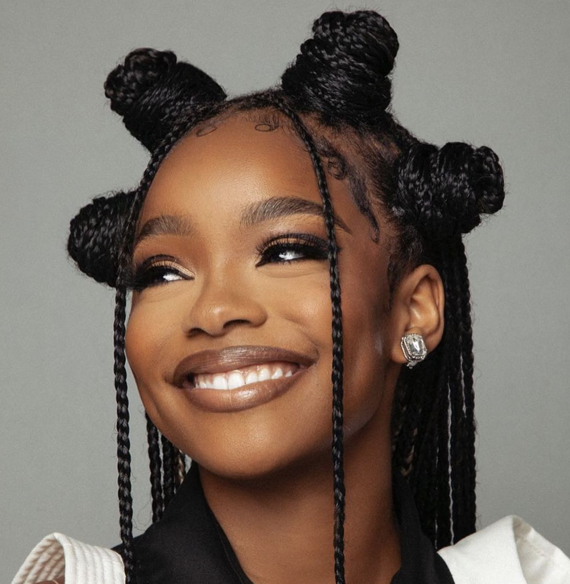 Marsai Martin wearing a regal braided crown updo with small bantu knots to complement her oval face shape.