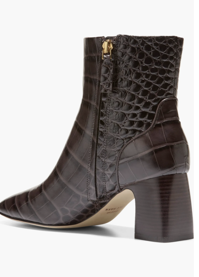 A close-up of the Cole Haan Gemma Bootie in dark chocolate brown croc-embossed leather, featuring a pointed toe, side zipper, and a sturdy block heel.