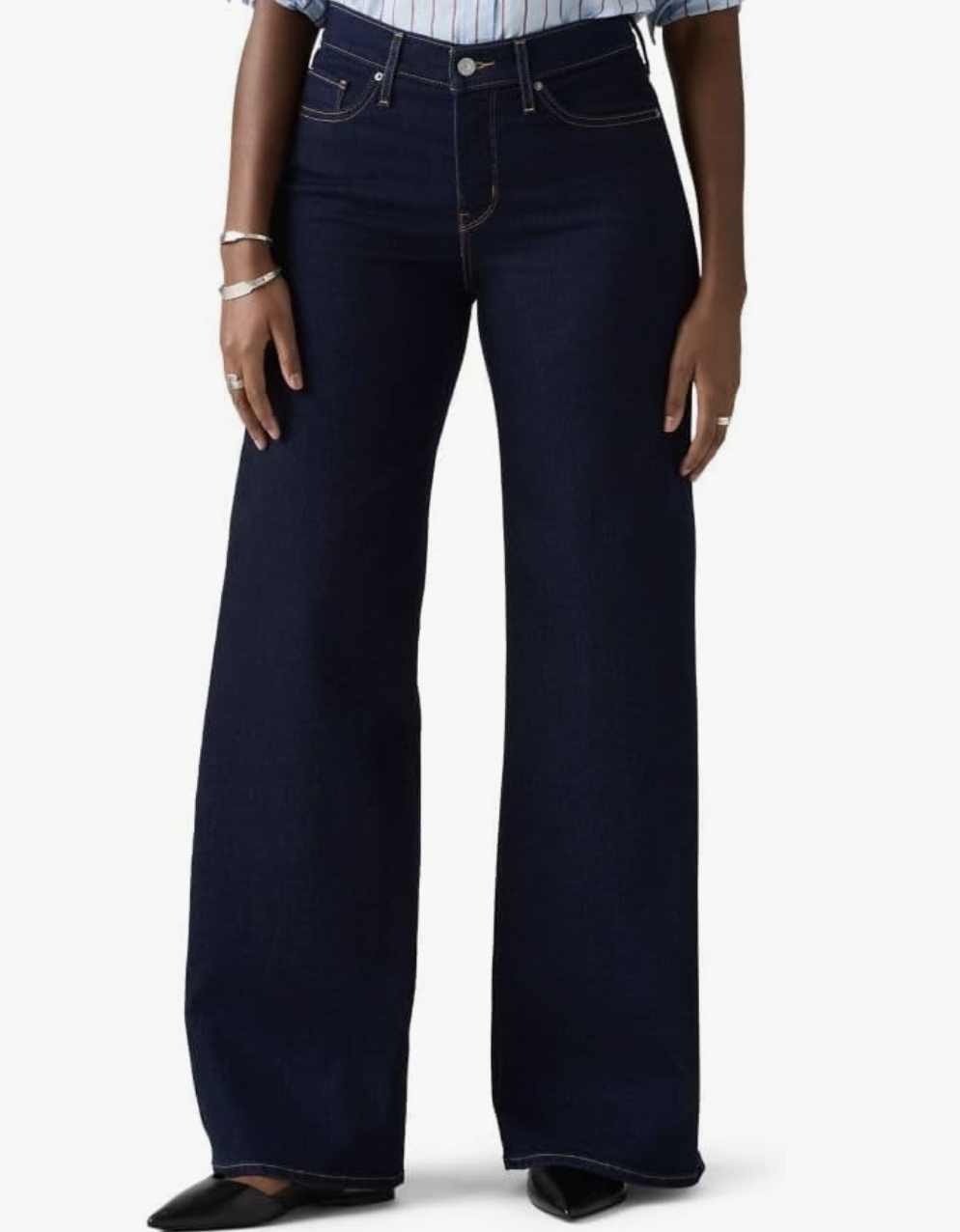 pair of pro stylist-recommended Levi's 318 Shaping Wide Leg jeans in a dark wash, styled with black pointed-toe flats for a "Skirt Over Pants" layering formula.
