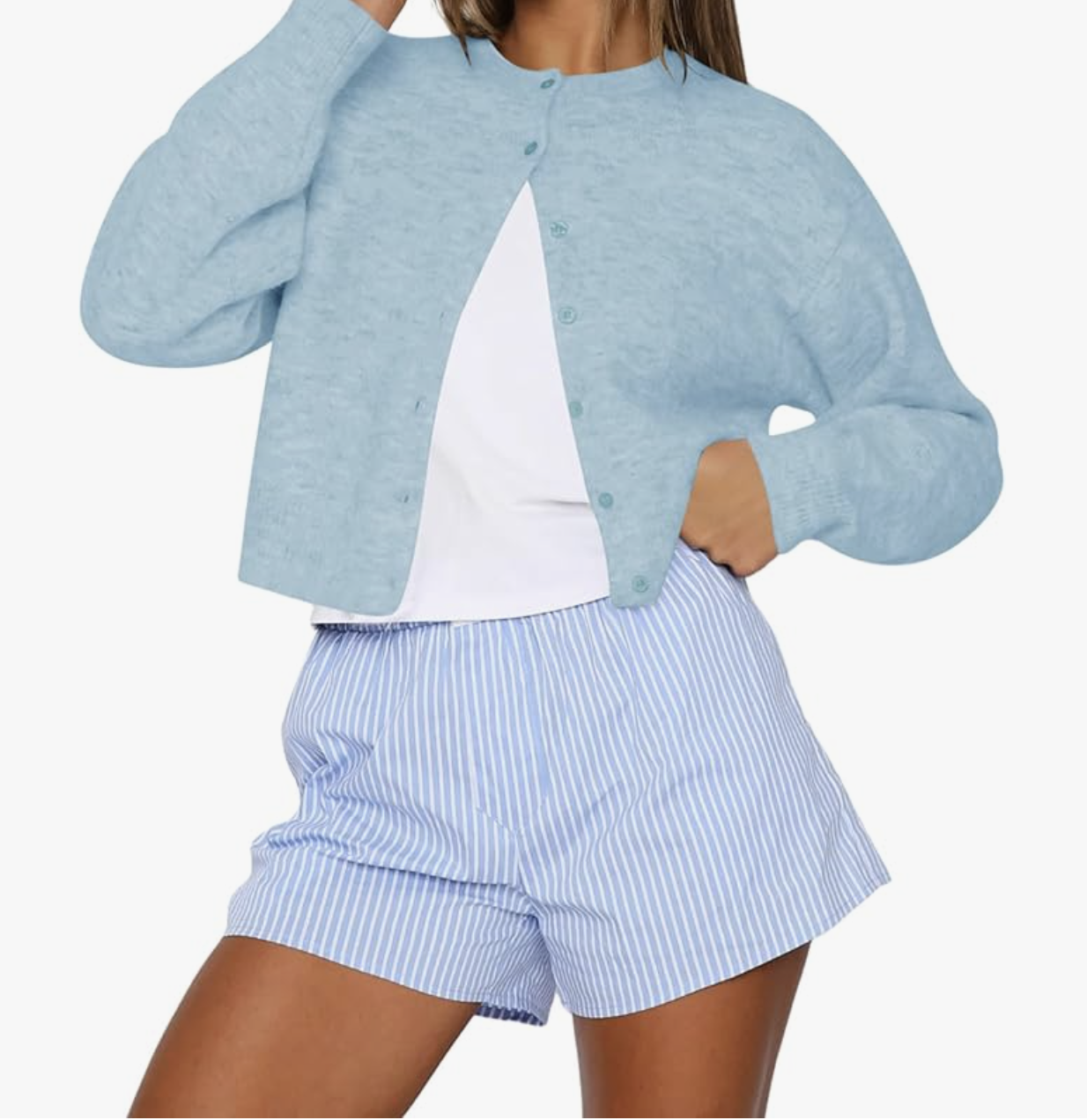 A light blue cropped button-up cardigan with long sleeves and a ribbed hem, styled with blue and white striped shorts.