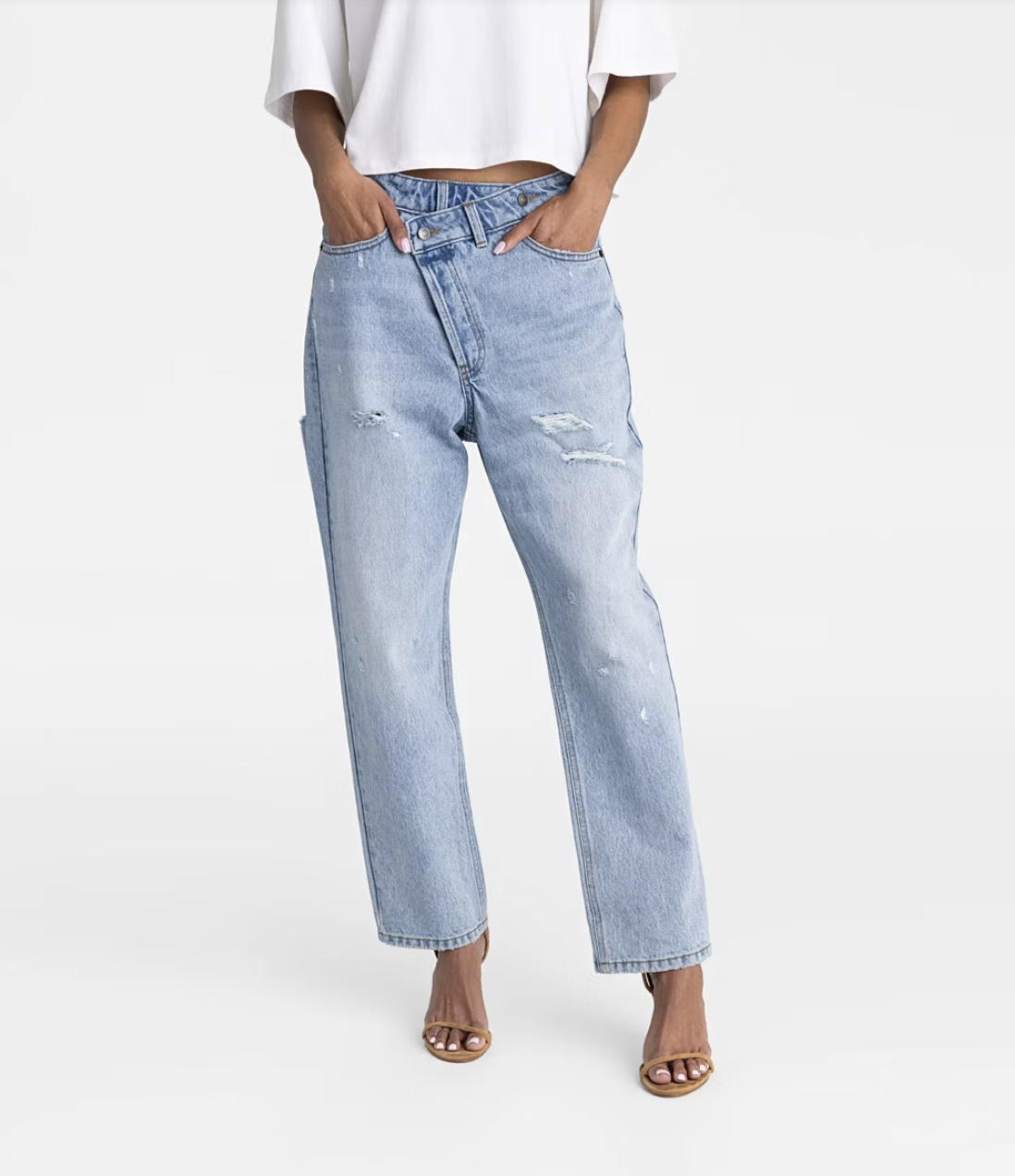 A pair of light blue tapered-leg jeans with a unique asymmetrical criss-cross button fly and a relaxed fit through the hips.