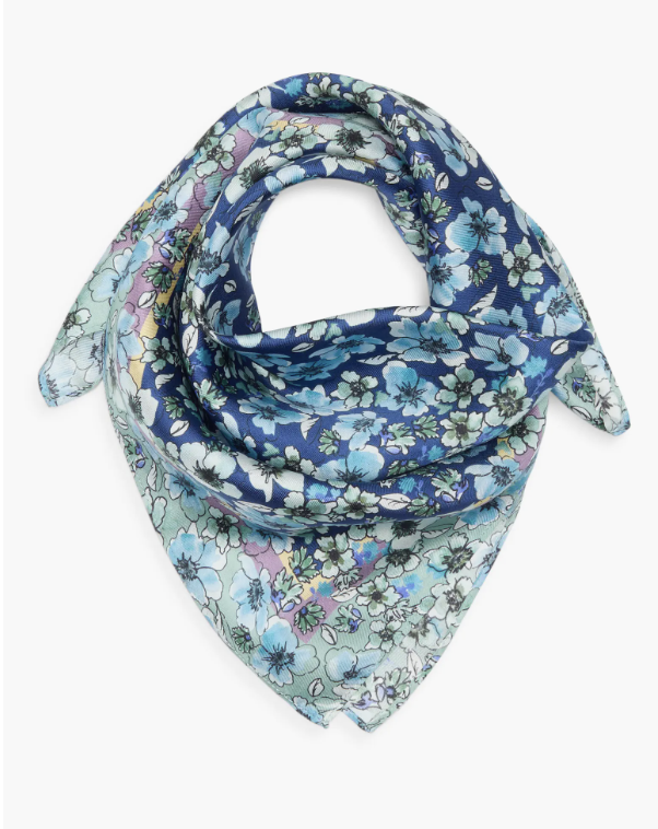A close-up shot of the Nordstrom Print Silk Square Scarf in Ditzy Blue Florals, showcasing its delicate blue and sage green floral patterns on a smooth silk fabric
