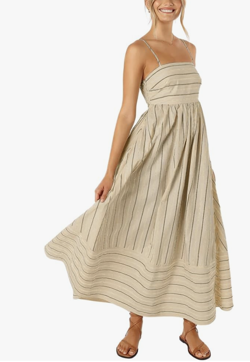 Woman wearing a chouyatou apricot and white vertical striped maxi dress with a smocked back and spaghetti straps, a sophisticated spring outfit for women over 60.
