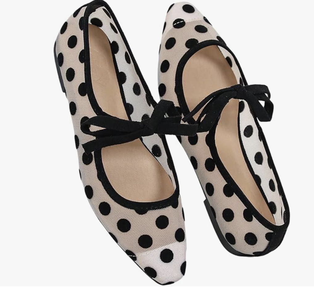 A pair of cream-colored mesh ballet flats with black polka dots and a black buckle strap, a trendy and lightweight shoe for styling white cropped jeans.