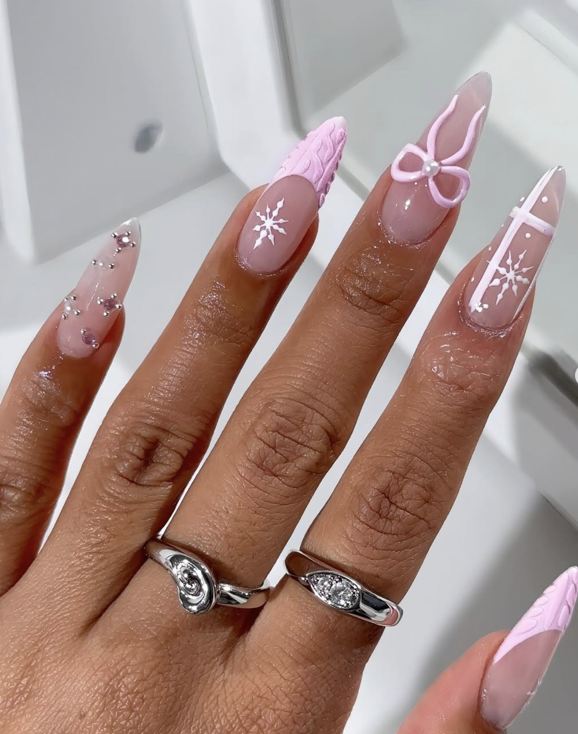 Sheer blush Christmas nails with delicate pink bow designs
