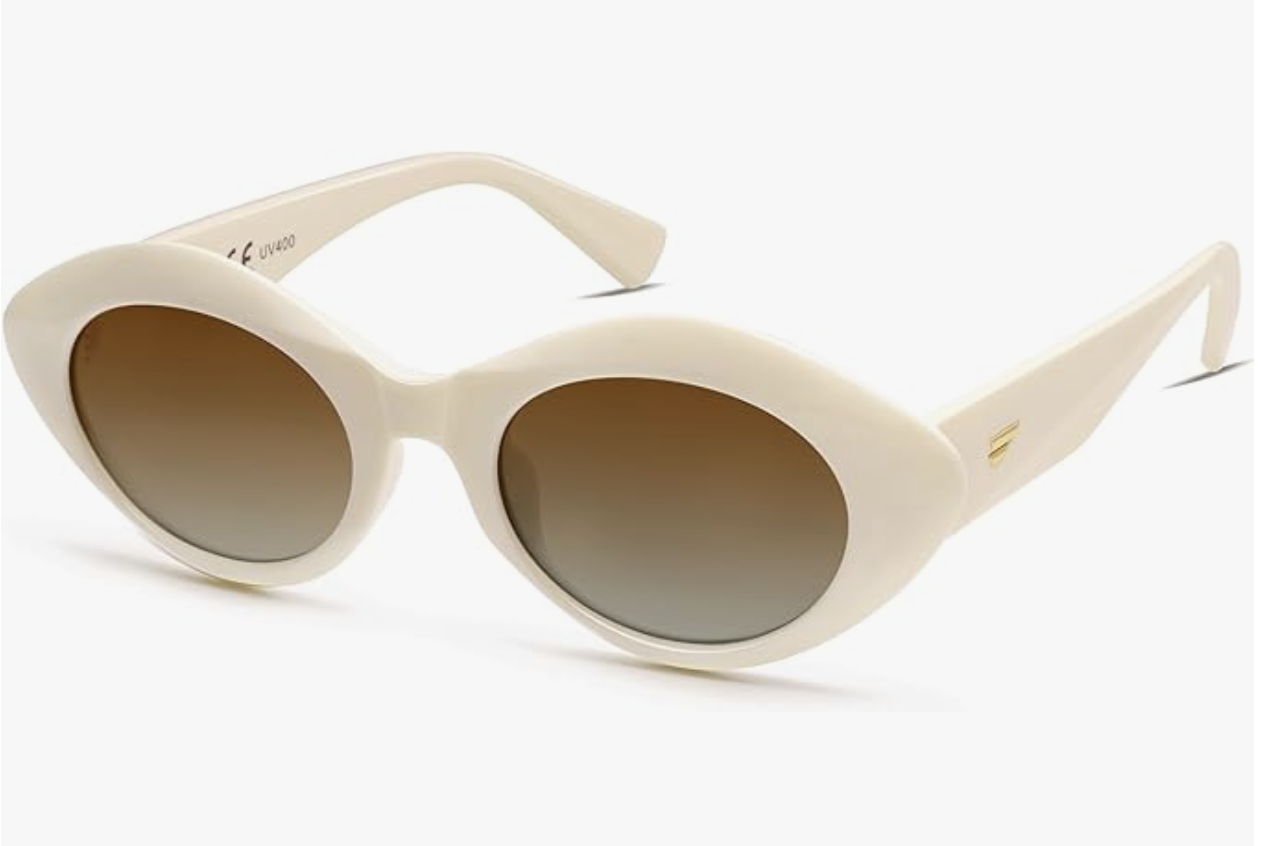 A pair of thick cream-colored oval sunglasses with brown tinted lenses, styled as an affordable accessory for a Mediterranean-inspired vacation outfit.