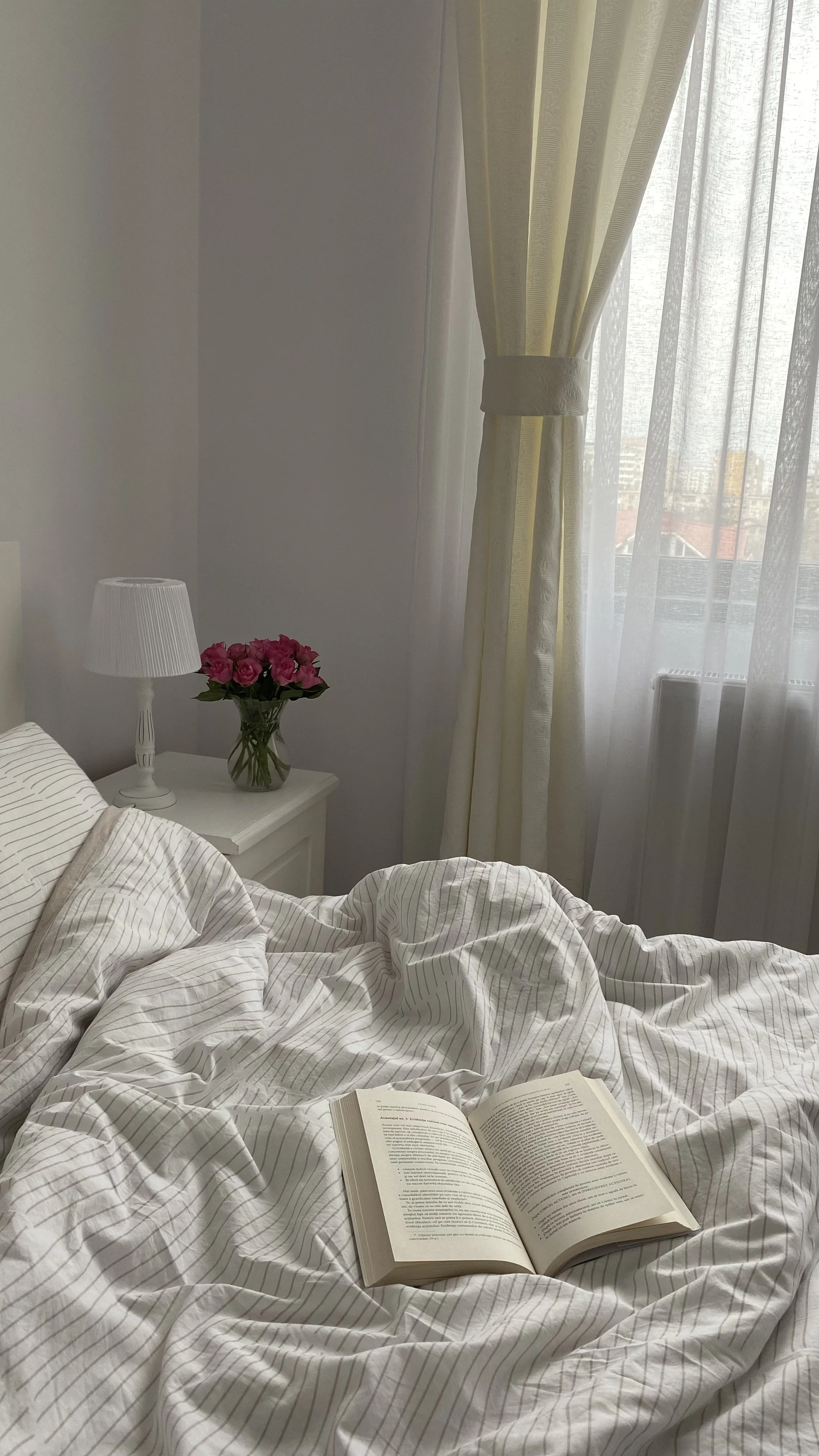 Morning sunlight entering a bedroom through open curtains