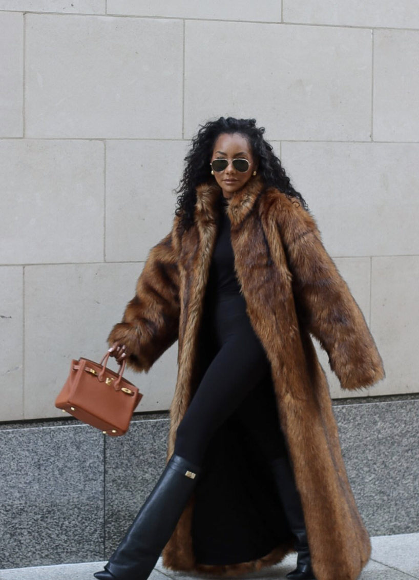 A long brown statement coat over black layers.