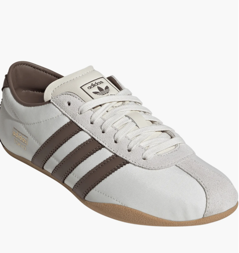 A pair of Adidas Tokyo Low Top sneakers in white leather with dark brown stripes and a classic gum sole, shown on a white background.