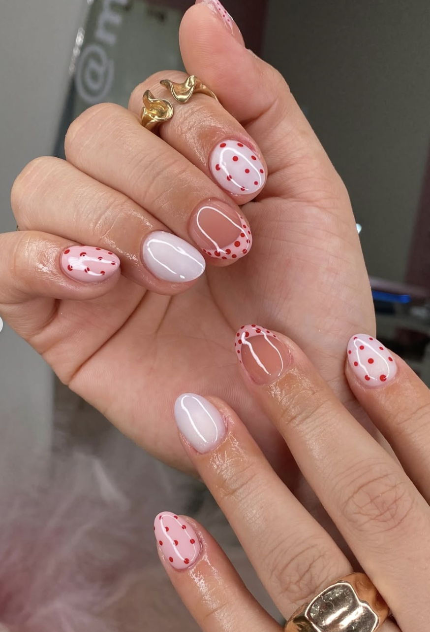 Long, oval-shaped nails with a glossy, semi-sheer pink base coat, beautifully decorated with delicate hand-painted pink and white daisy floral patterns.
