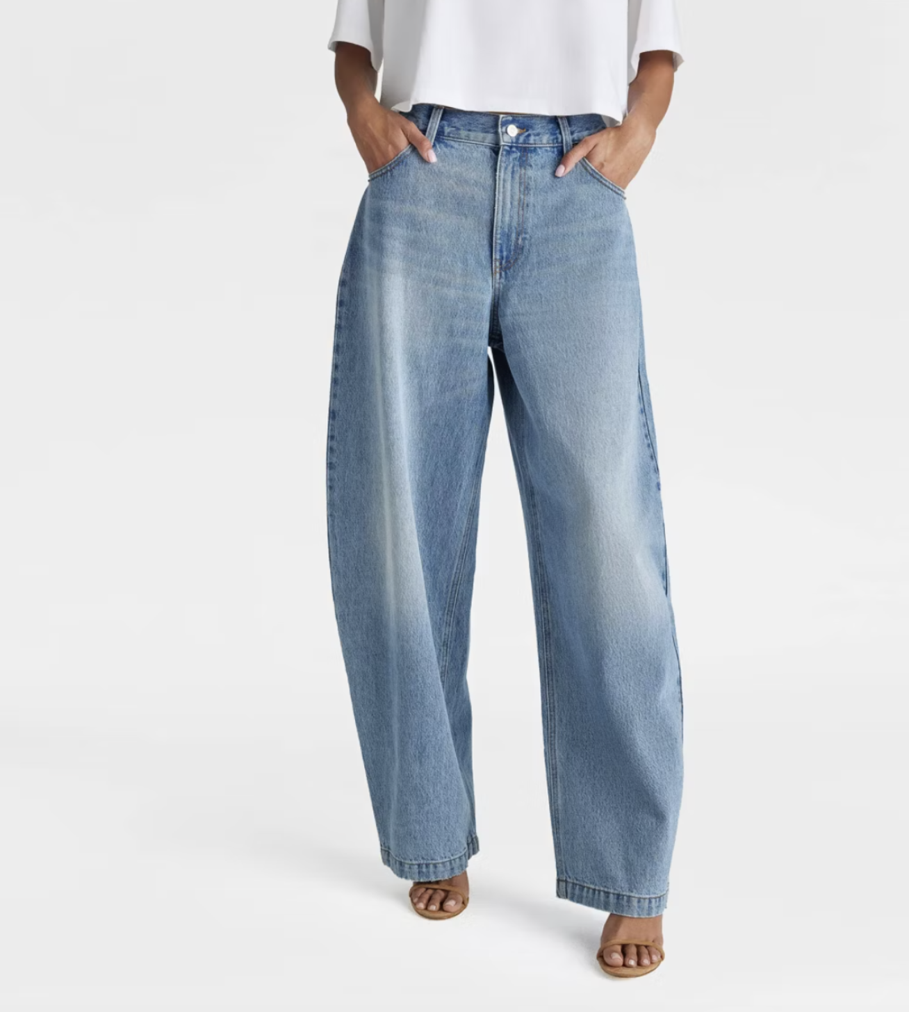 A pair of light blue mid-rise barrel leg jeans with a curved, wide-leg silhouette and traditional five-pocket styling.