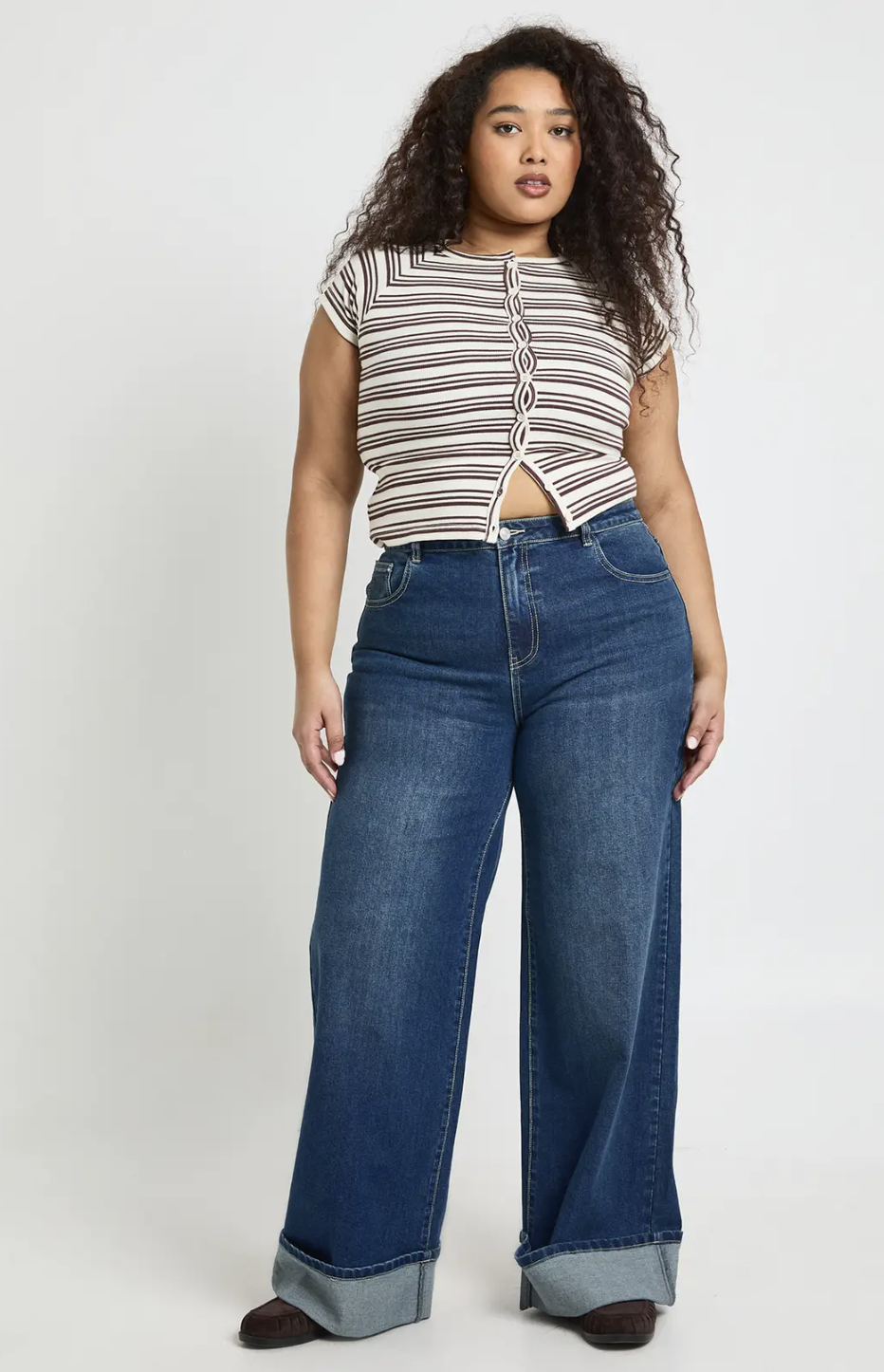 Model wearing Boohoo Plus Turn Up High Waist Wide Leg Jeans featuring a dramatic folded cuff at the hem, styled to add visual balance and hip definition for a rectangle or athletic figure.
