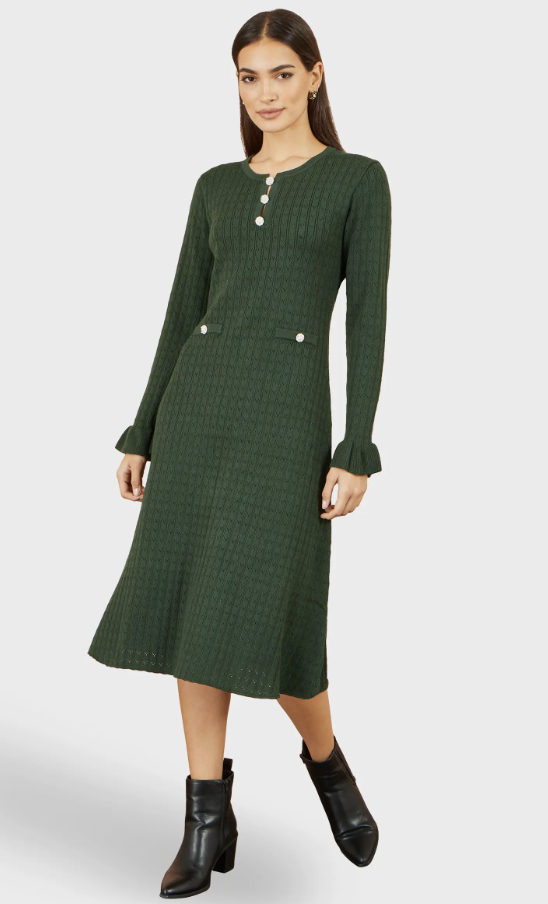 Navy long-sleeve knit midi dress styled with chocolate ankle boots and a camel coat.
