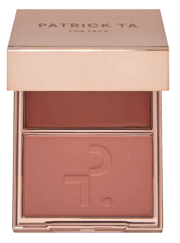 An open Patrick Ta Double-Take Crème and Powder Blush compact in the shade She’s Blushing, featuring a duo of deep toasted rose cream and matching powder in a rose gold case.