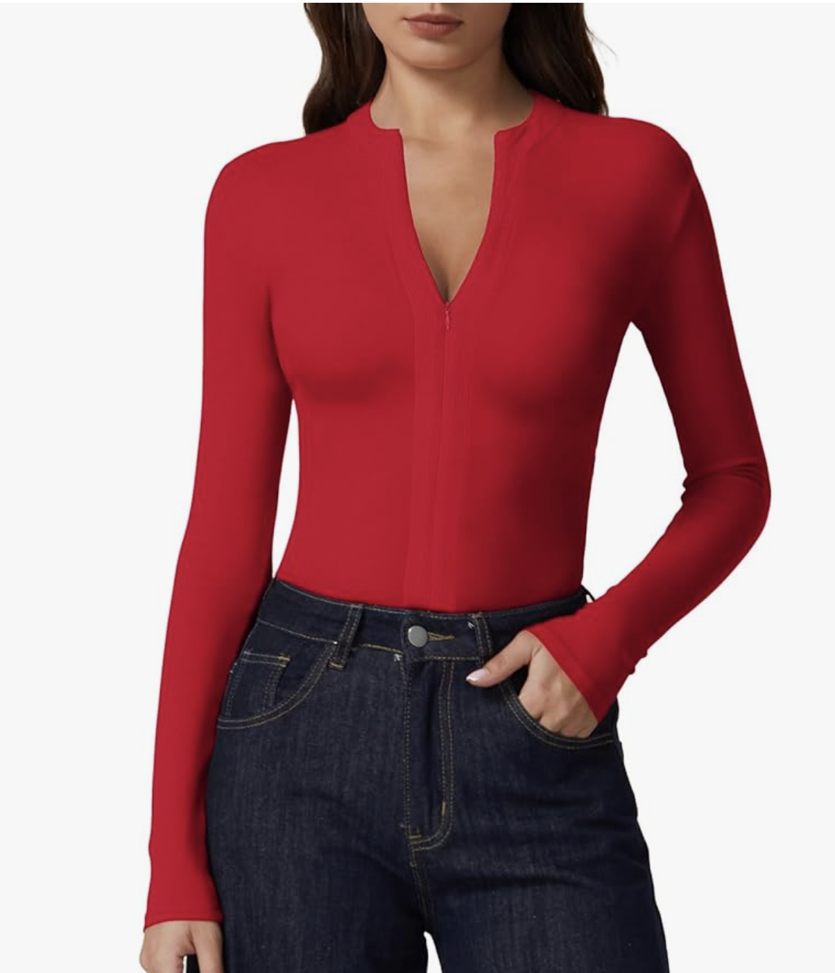 A close-up of a woman wearing a fitted, long-sleeve red half-zip ribbed knit sweater tucked into dark wash high-waisted denim jeans.