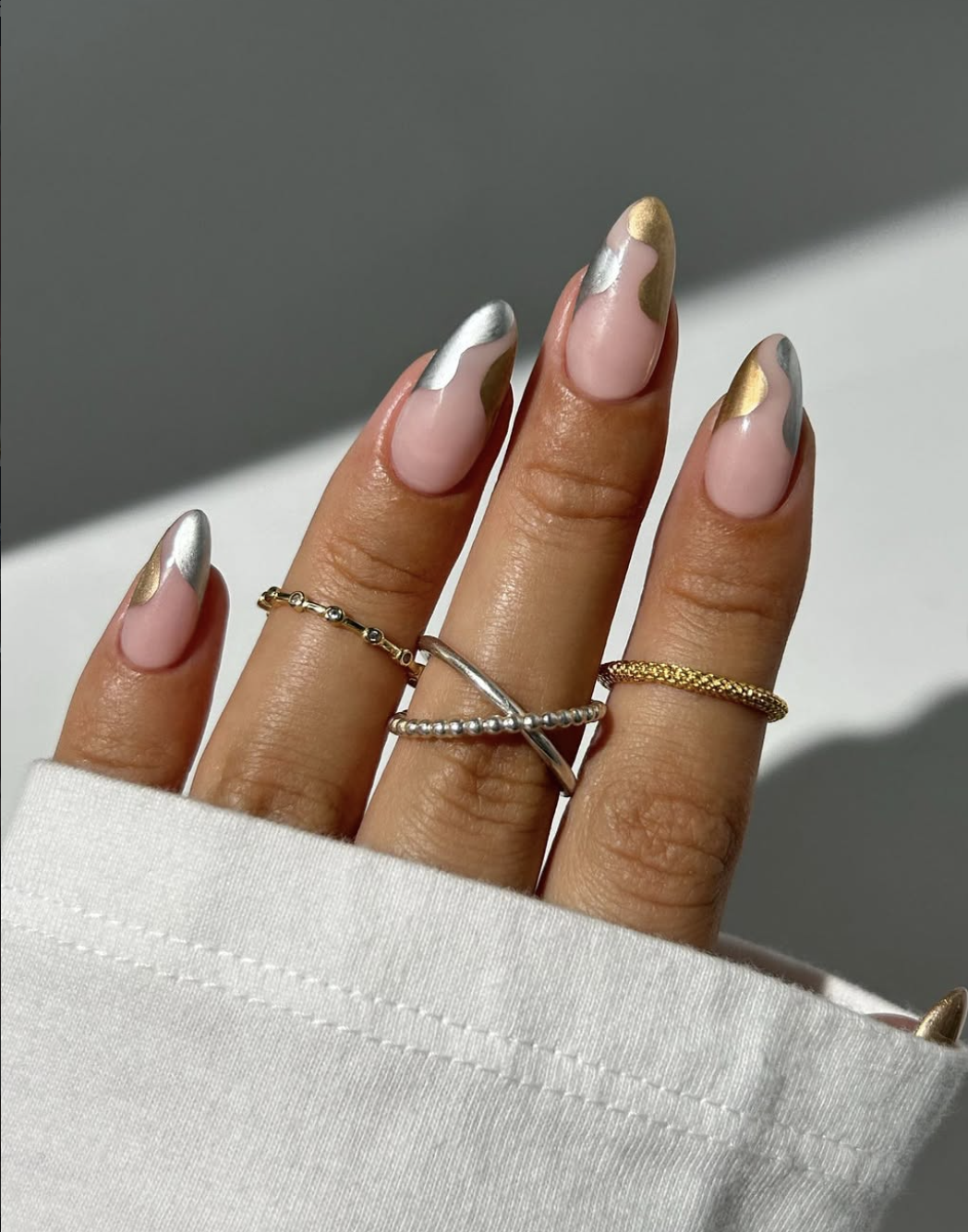 Minimal fall nail art with gold, silver and gunmetal accents on a sheer base.