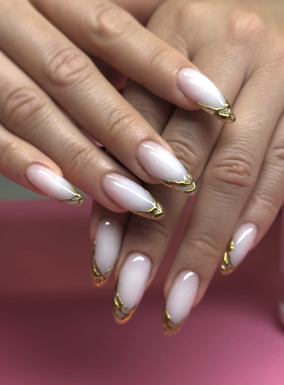 : Long, almond-shaped nails featuring a soft milky white base coat finished with a luminous, high-shine pearl chrome glaze.