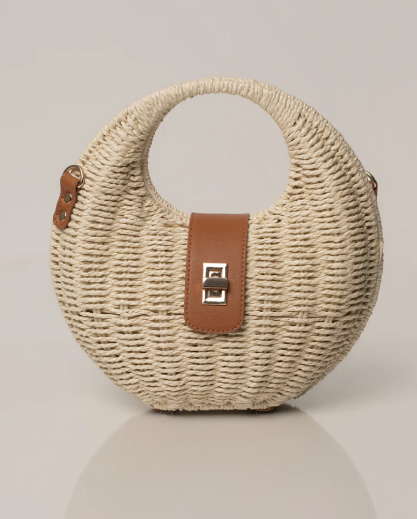 A structured beige woven tote bag with smooth top handles, perfect for a luxury resort vacation aesthetic.