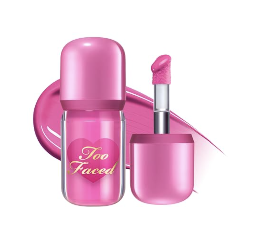 Bottle and applicator of Too Faced Love Flush Glowing Liquid Blush in a vibrant pink shade with a heart design.