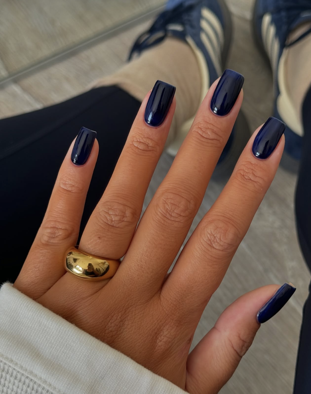 Short natural nails painted in an inky navy-black cream polish.