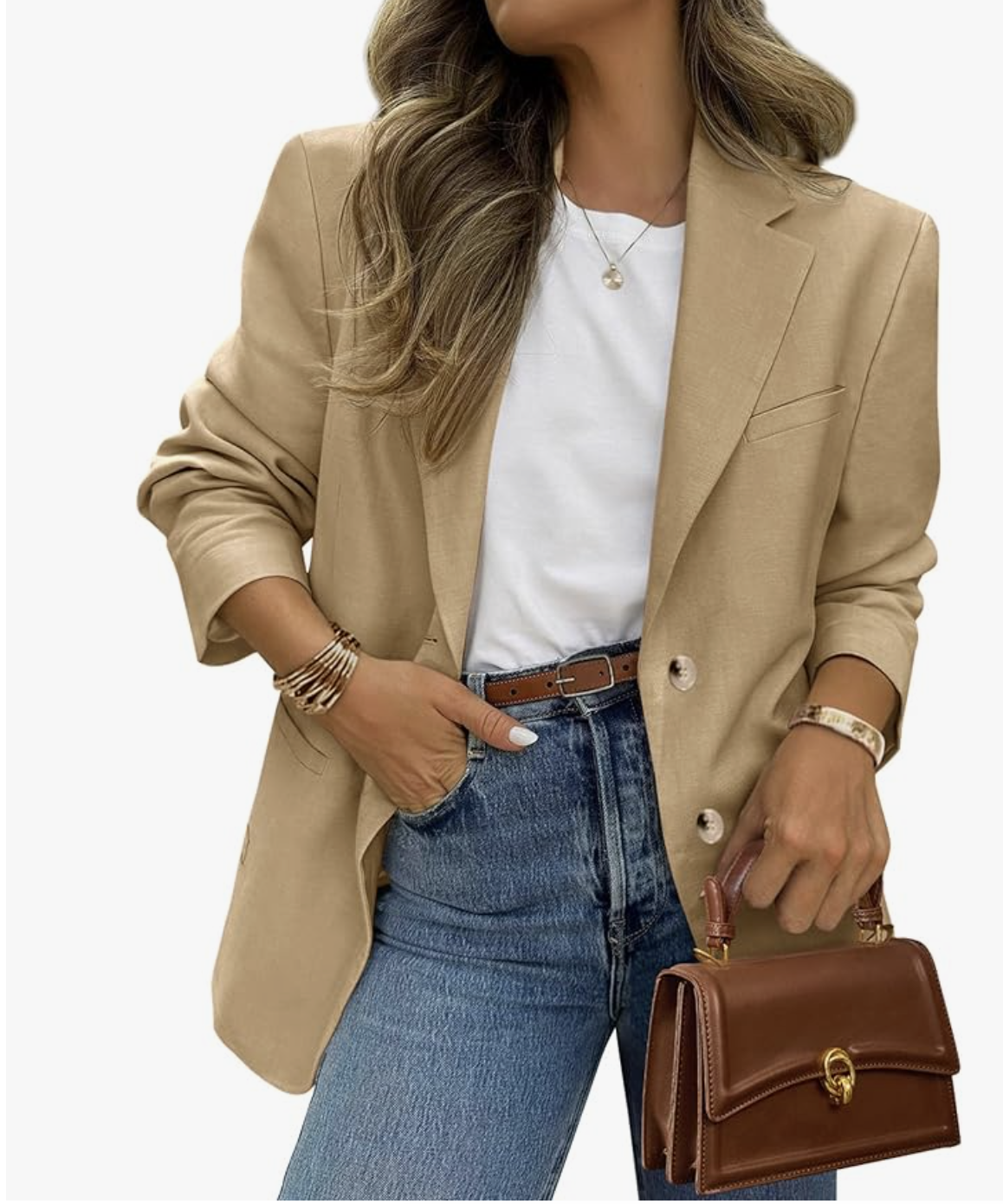 A woman styling a tan linen-blend blazer over a white t-shirt and straight-leg jeans, accessorized with a gold pendant necklace and a brown leather crossbody bag for a polished spring look