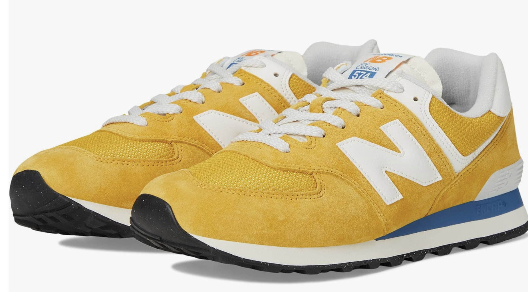 Side view of New Balance Classics U574v1 sneakers in mustard yellow and cream with a low-profile retro silhouette.