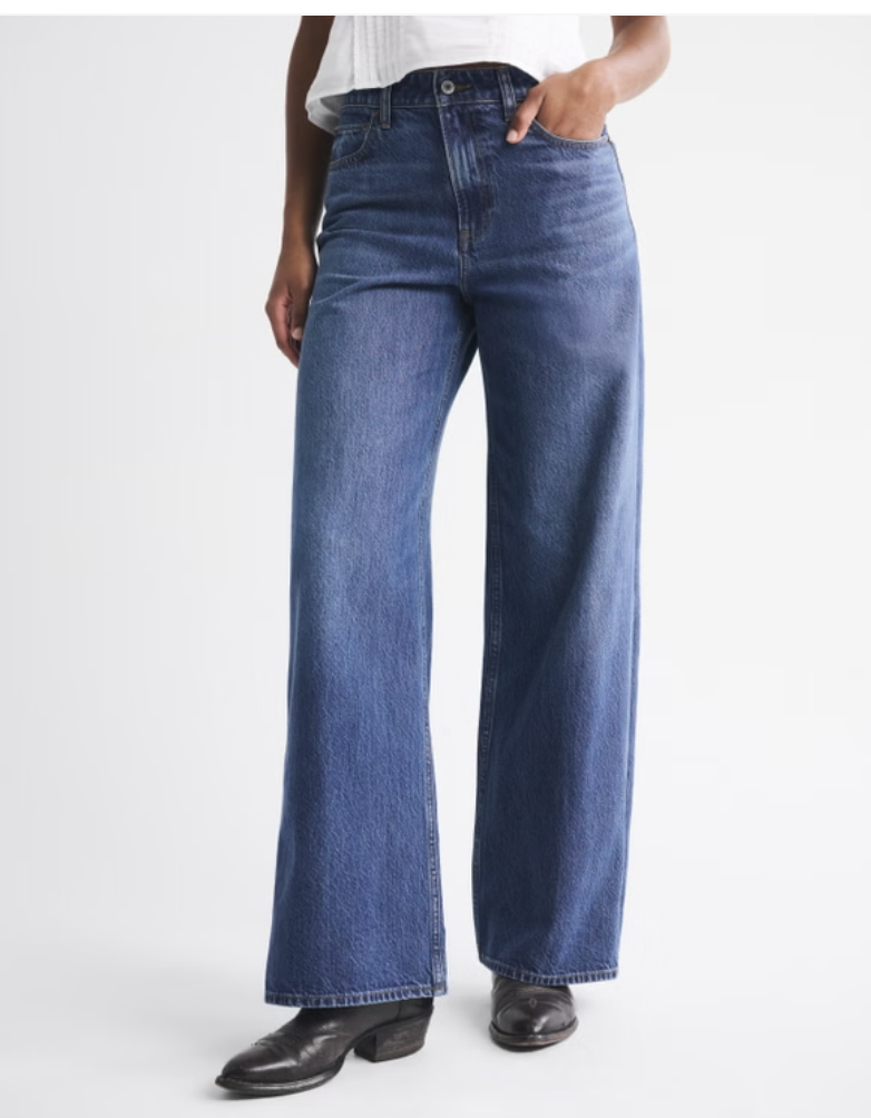 A close-up of a woman wearing Abercrombie Curve Love high-rise wide-leg jeans in a medium wash, a perfect denim base for structured blazer outfits.