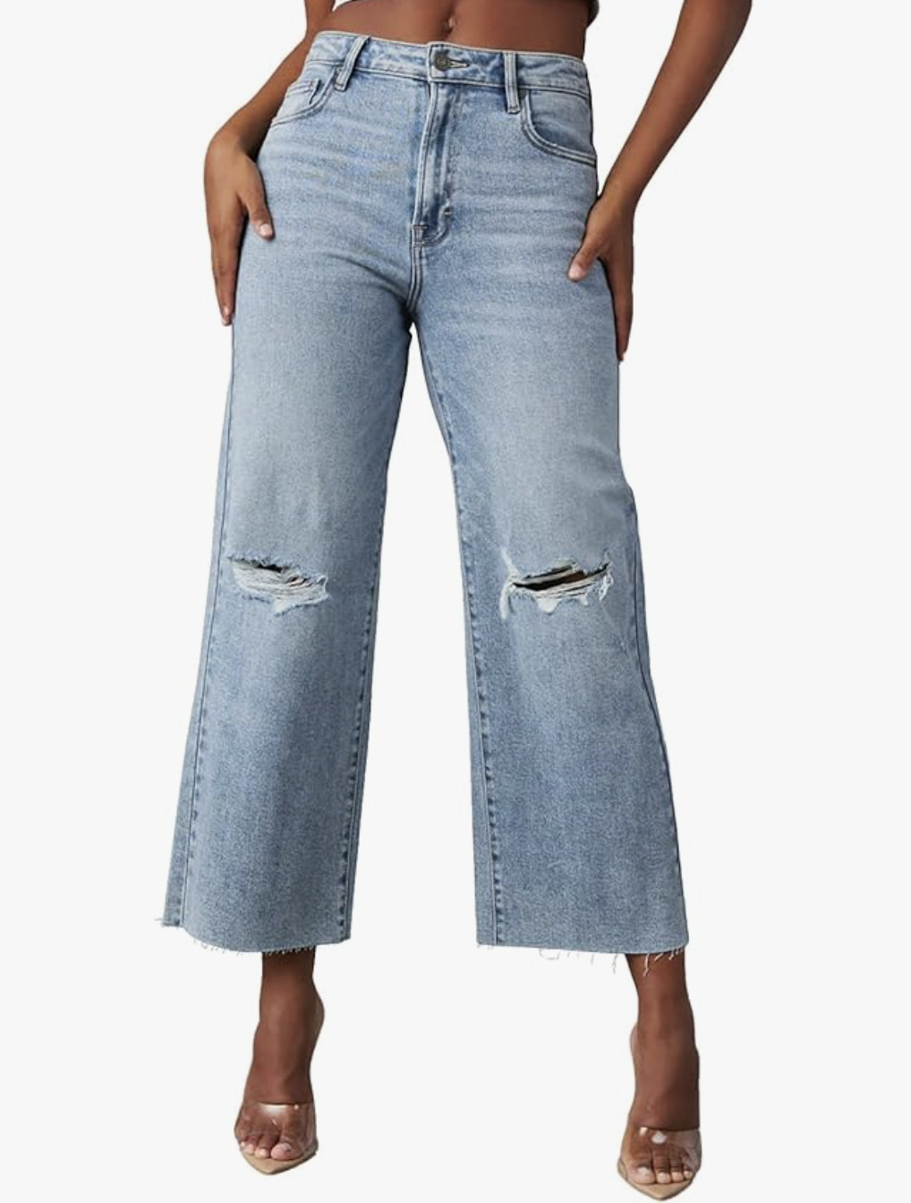 A studio product shot of light-wash High Waisted Straight Ankle Wide Leg Jeans from Amazon, featuring a raw hem and styled with clear-strap heels.